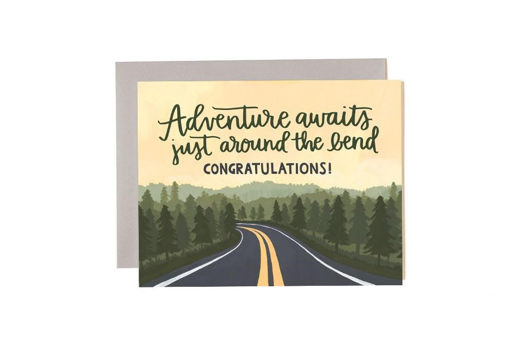 Illustration of a road leading into the woods with the message "Adventure awaits just around the bend Congratulations!" above the tree line.