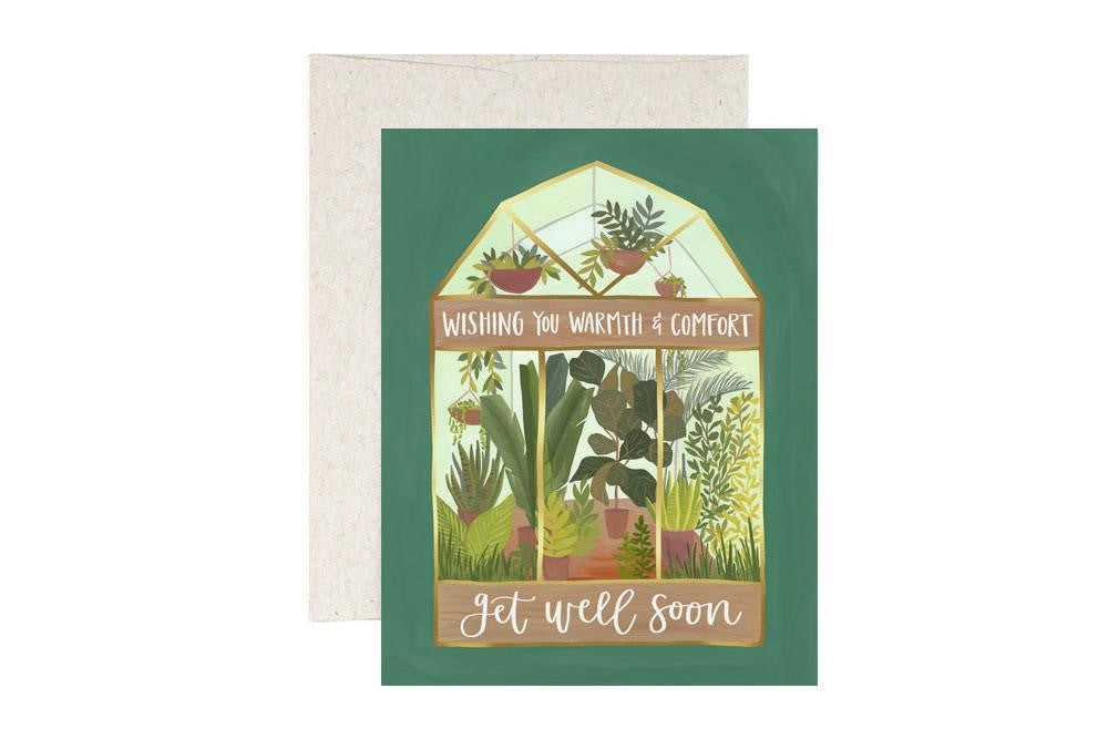 A green card featuring an illustration of a glass greenhouse and the message "Wishing you warmth & comfort get well soon."