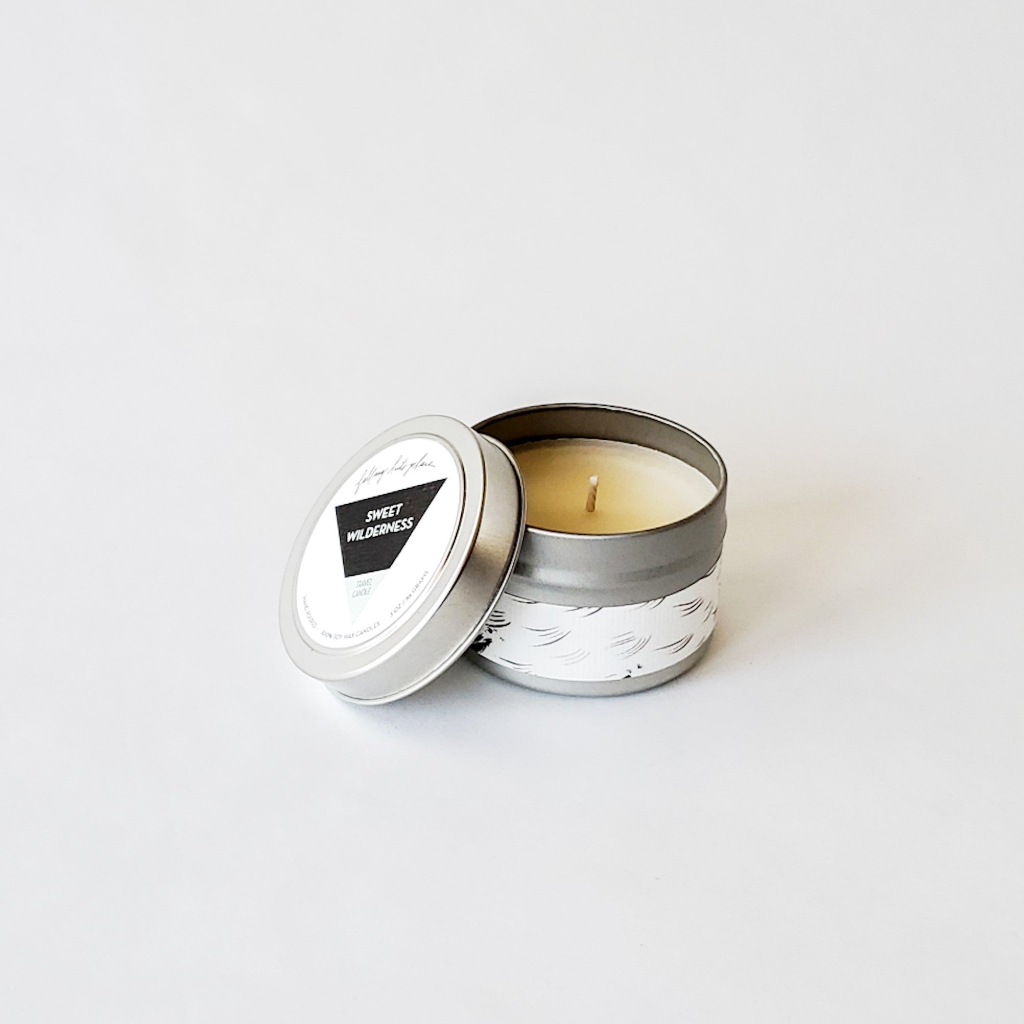 Artistic jar and tin candles with black and white labels. 