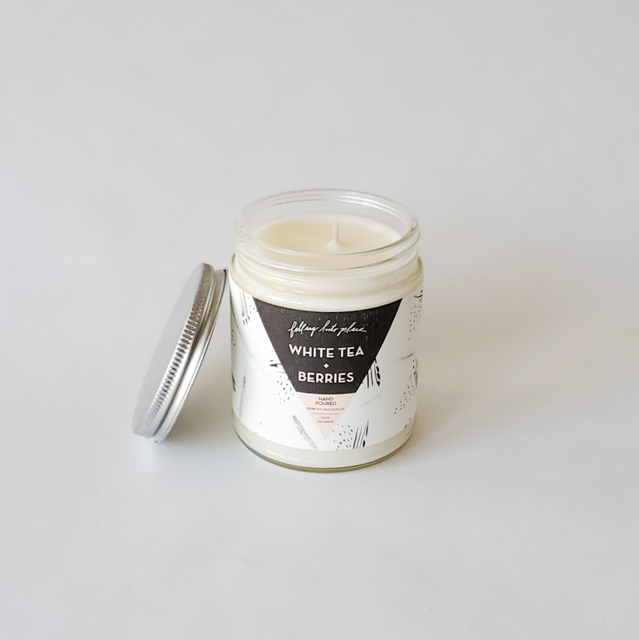 Artistic jar and tin candles with black and white labels. 